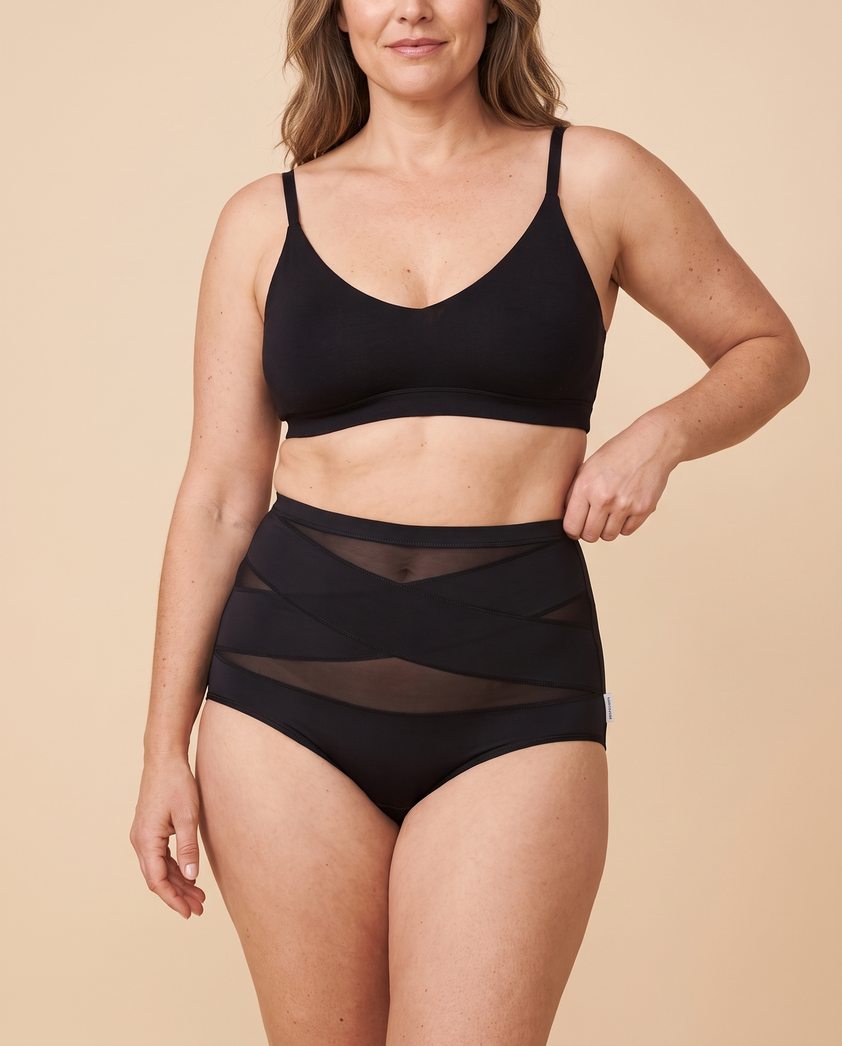 Woman wearing black high waisted tummy control knickers with cross band mesh panels