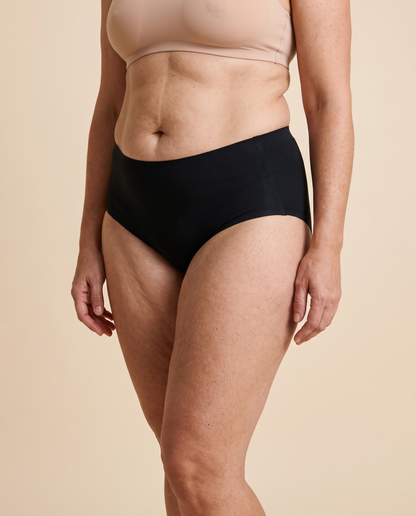 Woman wearing black high waisted seamless knickers, front view