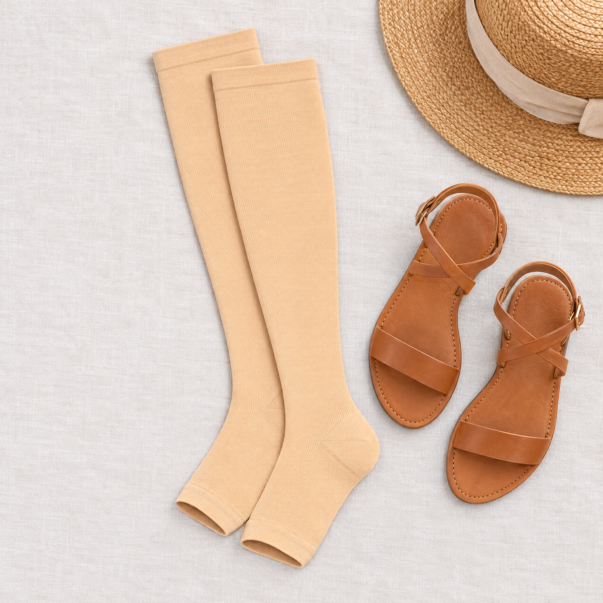 Flat lay of open toe knee high compression socks with sandals