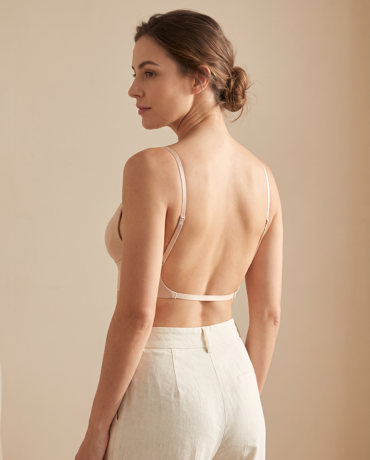 Woman wearing the beige low back bra, rear view showing the thin straps and low band